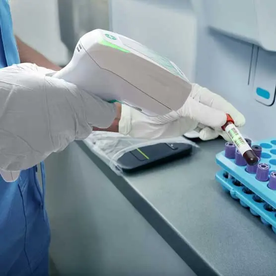 Datalogic Gryphon GD4690 HC disinfectable 2D healthcare USB scanner reading a blood sample tube barcode in a laboratory