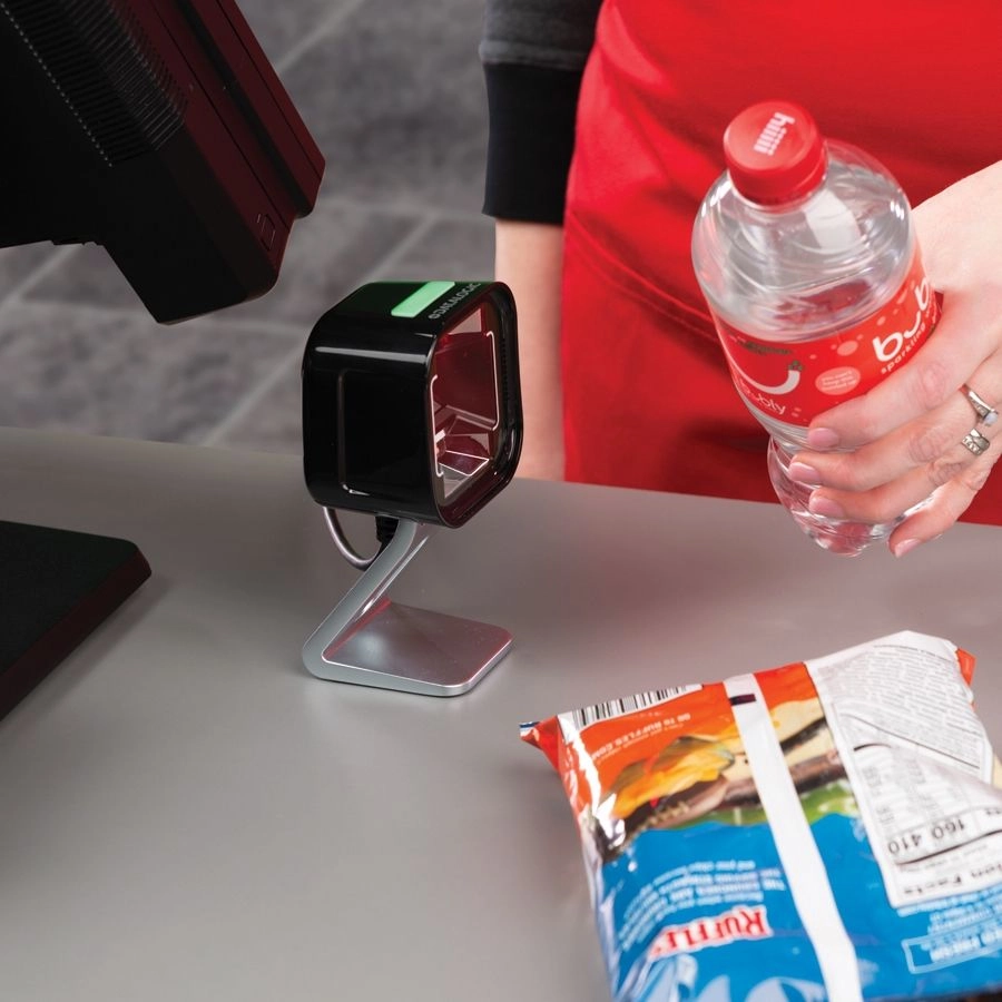 Datalogic Magellan 1500i USB 1D/2D presentation barcode scanner scanning POS items at a retail checkout