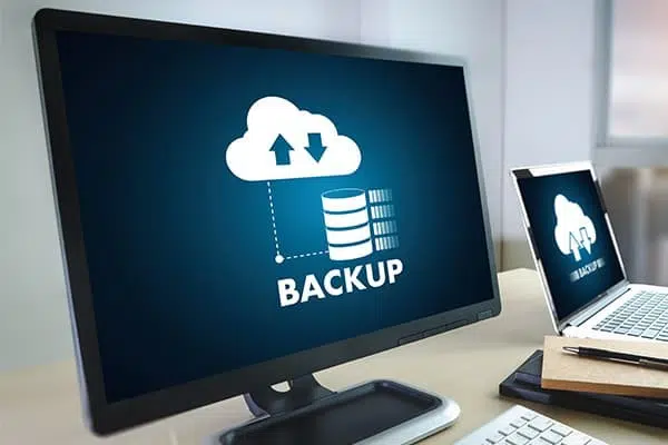 Cloud backup icon on office screens for MagicPOS BackupPlus database backup, securing GastroSoft and PosSoft POS data with daily checks and restore support.