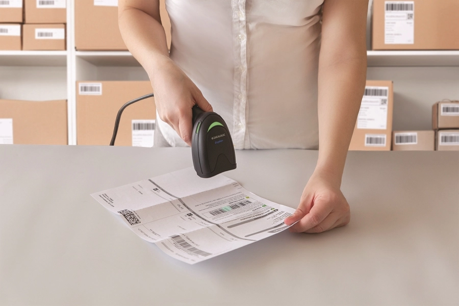 Datalogic Gryphon I GD4220 black corded USB 1D barcode scanner scanning shipping labels in a warehouse or retail stockroom